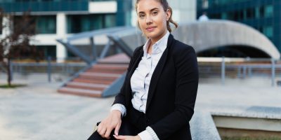 Beautiful businesswoman holding notebook in business district
